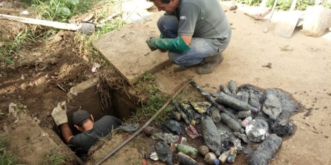 homens limpando boca de lobo na Rua Fuji