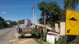 morador carregando colchão em rua atingida pelas chuvas