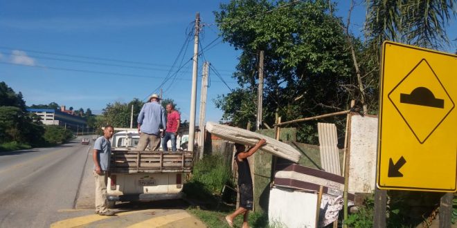 morador carregando colchão em rua atingida pelas chuvas