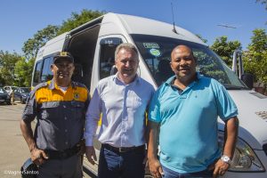 secretário de trânsito e transportes Joaquim Brechó posam com um agente de trânsito e um motorista de transporte escolar diante de vã escolar