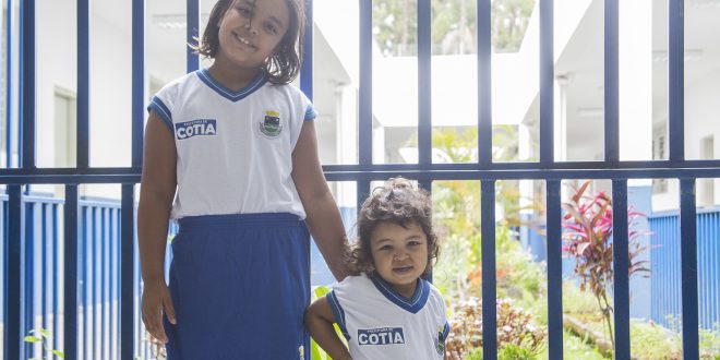 duas alunas de cotia posam para foto com os novos uniformes