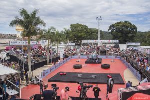 estrutura do força bruta com várias arquibancadas lotadas e competidores numa pequena arena