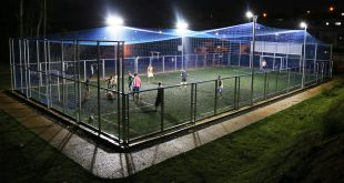 foto noturna da quadra de futebol society do jardim vargem grande com os refletores ligados e iluminando o local enquanto atletas disputam uma partida