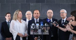 doria falando à imprensa com autoridades ao seu redor
