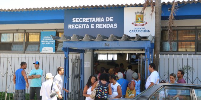 fachada da secretaria de receitas e rendas de carapicuíba, com uma longa fila na porta