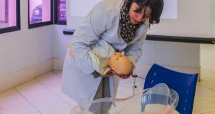 médica manipulando boneca em palestra sobre gravidez de alto risco