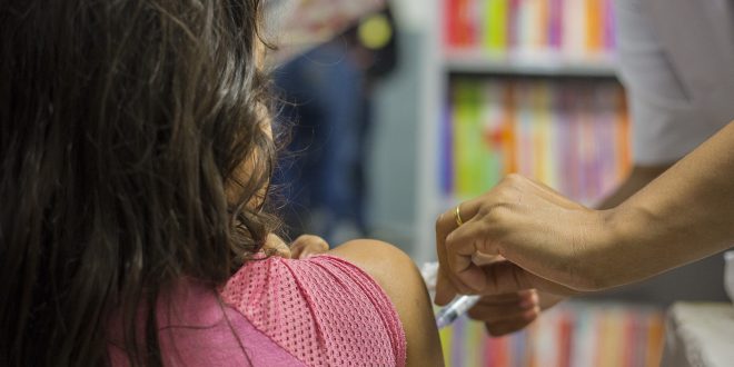 criança recebendo dose da vacina contra a febre amarela em cotia