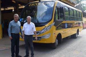 Prefeito Claudio Góes e o diretor do Departamento de Educação, José Weber posam para foto diante do novo ônibus escolar