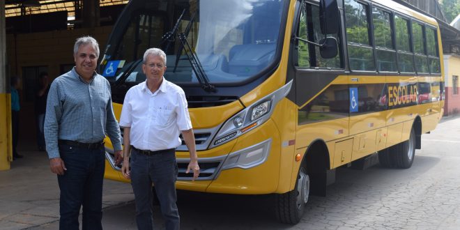 Prefeito Claudio Góes e o diretor do Departamento de Educação, José Weber posam para foto diante do novo ônibus escolar
