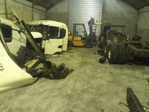 interior do desmanche, com várias peças de caminhões empilhadas