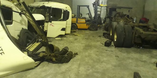 interior do desmanche, com várias peças de caminhões empilhadas