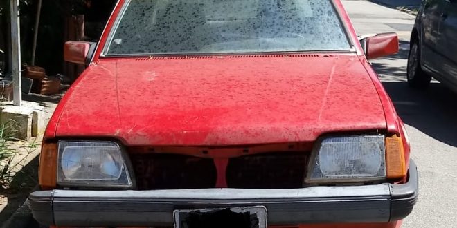 vista frontal de carro antigo que foi roubado e depois abandonado