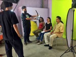 alunos de cotia preparam gravação de imagens com três pessoas sentadas em frente à câmera