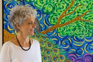 Regina Steurer, fundadora do Projeto Âncora, fotografada em frente a painel artístico