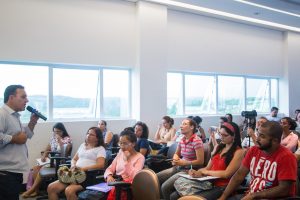 auxiliares reunidos em auditório ouvindo o prefeito rogerio franco