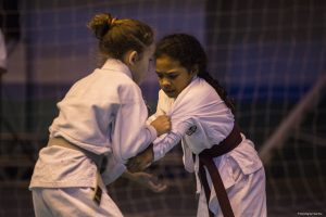 duas jovens karatecas disputando uma partida