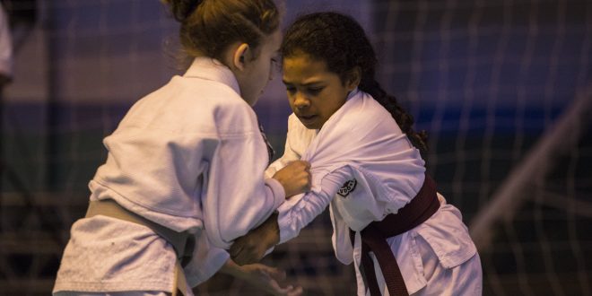 duas jovens karatecas disputando uma partida