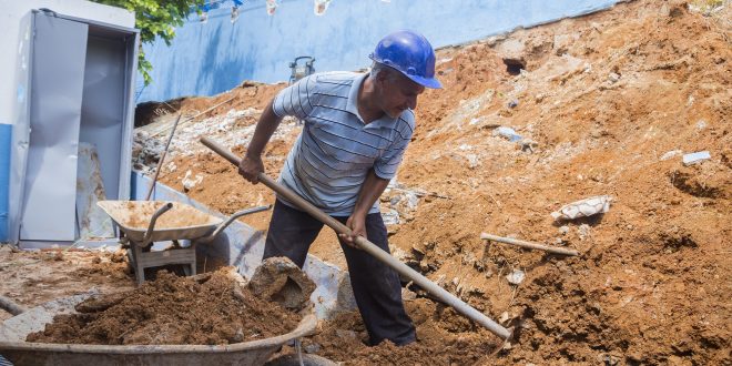 homem trabalhando em obra do muro