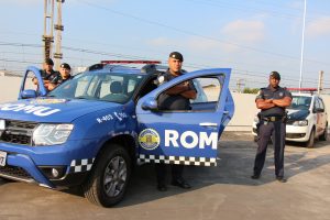 uma viatura da romu da guarda civil de carapicuíba com quatro guardas posando em volta com uma viatura da guarda ao fundo