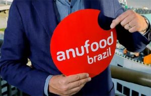 homem segurando placa da 'anufood brazil'