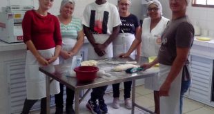 participantes do curso de panificação artesanal posam para foto em volta de mesa