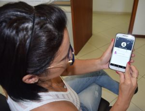 uma mulher conferindo o holerite eletrônico em um celular