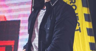 luan santana sorri no palco com um microfone em mãos