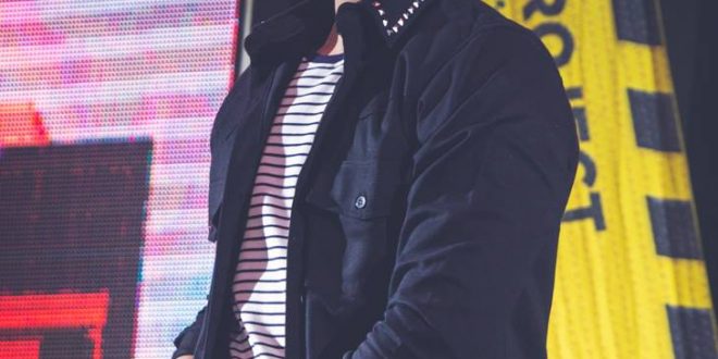 luan santana sorri no palco com um microfone em mãos