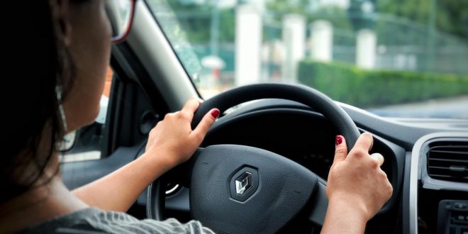 vista traseira direita de uma mulher conduzindo um veículo da marca renault