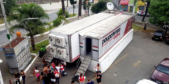 uma unidade do poupatempo móvel com algumas pessoas próximas