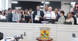 padre José Maria Falco, vereadores e autoridades posam com homenagem em mãos