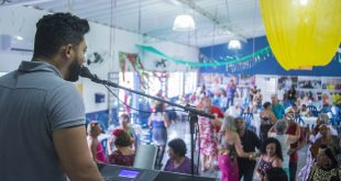 músico tocando teclado diante de grande público dançante da terceira idade