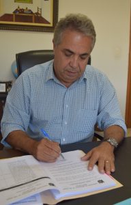 prefeito cláudio goés em sua mesa assinando contratação da empresa