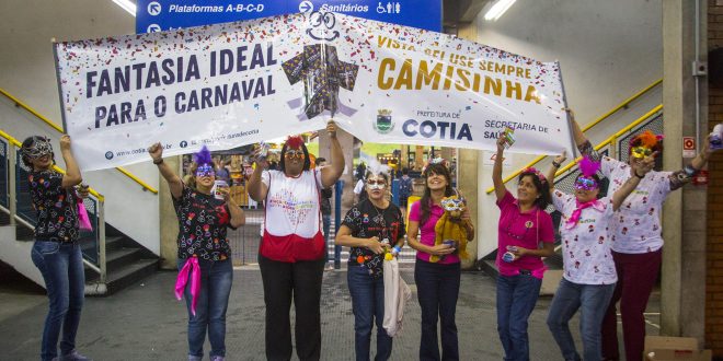 agentes da saúde caminham pelo terminal de cotia com faixas educativas