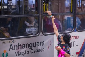 agente de saúde entrega panfleto a passageira de ônibus