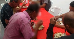 moradores de rua em mesa de abrigo