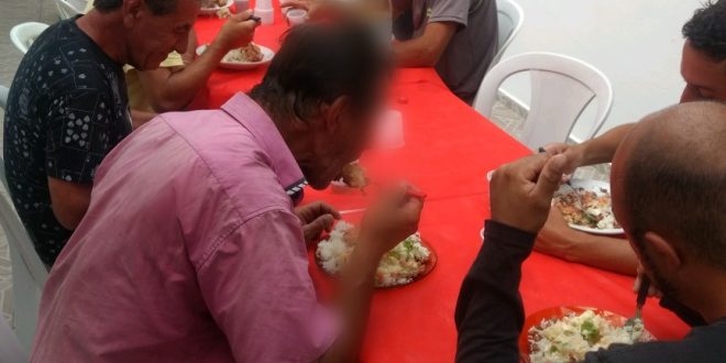 moradores de rua em mesa de abrigo