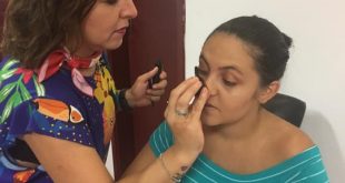 uma mulher sendo maquiada por outra