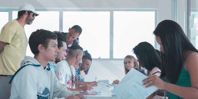 candidatos conversam com agentes para inscrições