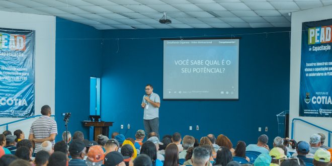 luis gustavo napolitano palestrando com dezenas de pessoas à frente do palco
