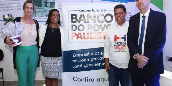 Gilmara Gonçalves, Marcos Neves e outras autoridades posam ao lado de faixa de divulgação do banco do povo