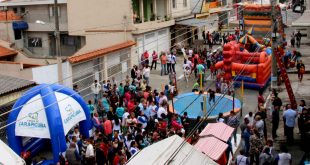 multidão reunida em meio a brinquedos e atividades em rua de carapicuíba