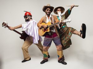 os rauzitos posam para foto caracterizados e com instrumentos em mãos ante um fundo branco