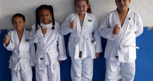 quatro alunos de diferentes tamanhos posam com quimonos novos