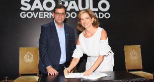 Prefeito Marcos Neves e Secretária Estadual de Desenvolvimento Social Célia Parnes posam para foto enquanto assinam repasse