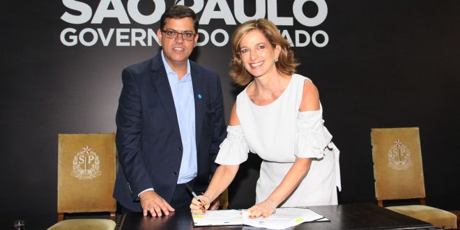 Prefeito Marcos Neves e Secretária Estadual de Desenvolvimento Social Célia Parnes posam para foto enquanto assinam repasse