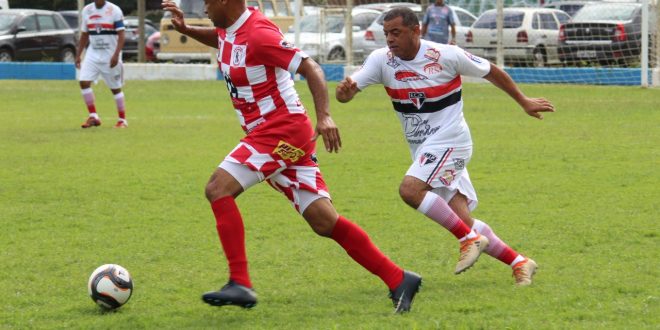 jogadores do Planalto e do Brasinha disputam uma partida de futebol