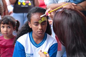 criança tendo seu rosto pintado