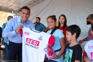 vice prefeitoalmir rodrigues sorri para câmera com camiseta do sesi ao lado de crianças