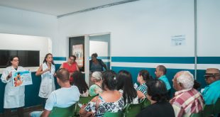 pacientes que aguardam atendimento acompanham esplanações sobre tuberculose dadas por agentes de saúde